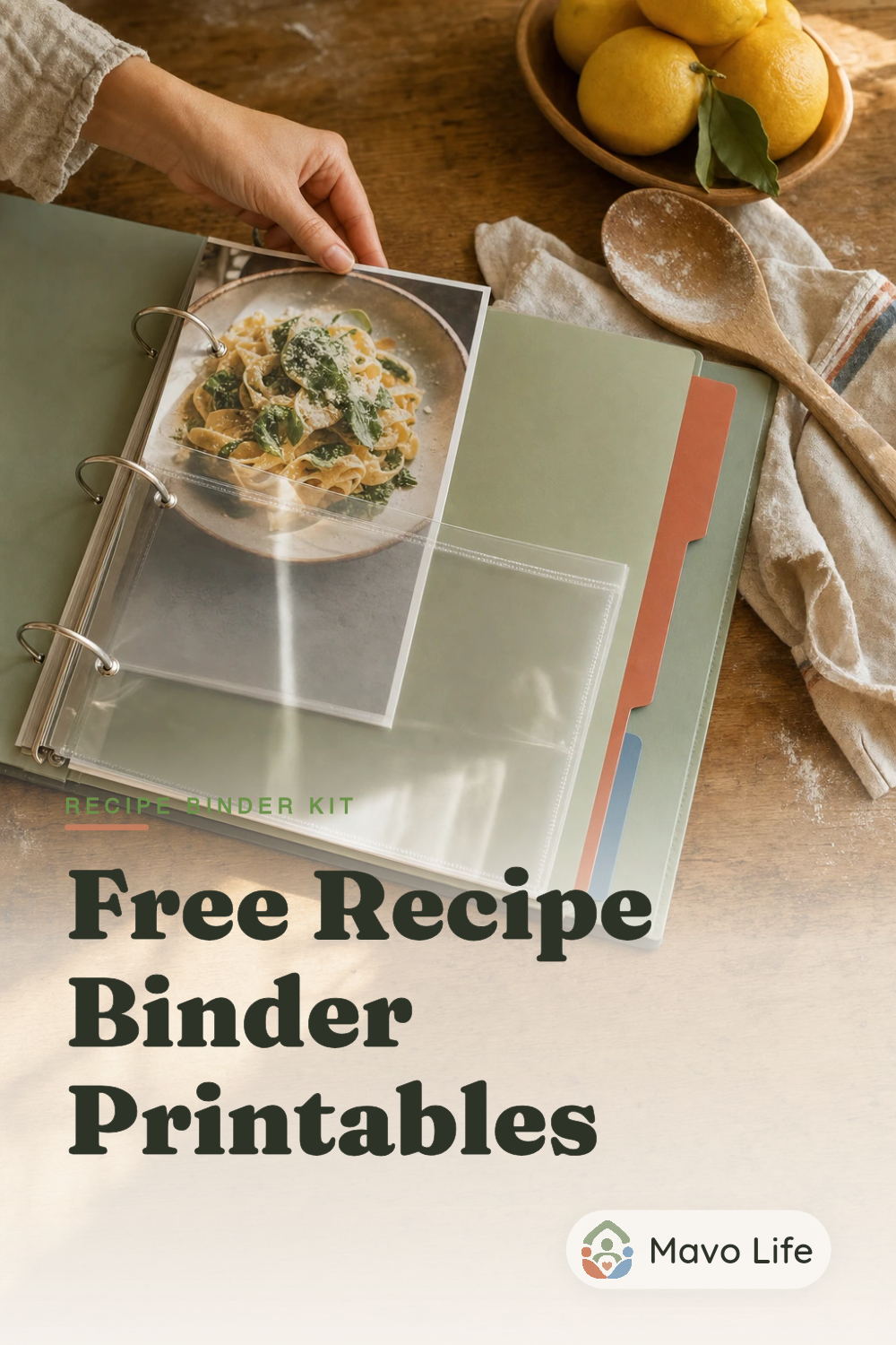 An adult files a food photograph into a protected page in an open family recipe binder beside lemons and a wooden spoon under the words Free Recipe Binder Printables